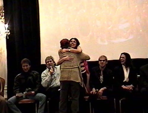 A trivia contest winner hops on stage to grab his T-shirt and grabs a hug from "ANGELA" at the same time!