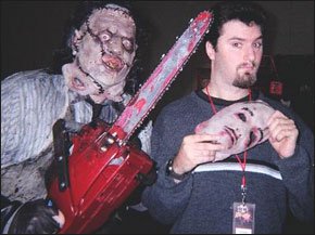 Jeff Hayes posing with a chainsaw-wielding monster at Rock and Shock