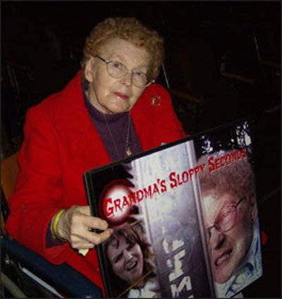 Barbara O'Connor holding Grandma's Sloppy Seconds poster art