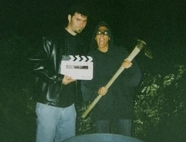 Felissa, dressed in her "intruder" outfit, holds a pickaxe while Jeff holds the RTSC clapboard